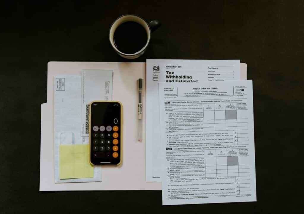 The Benefits of Hiring a CFO Outsourced for Your Business Growth 5 black Android smartphone near ballpoint pen, tax withholding certificate on top of white folder