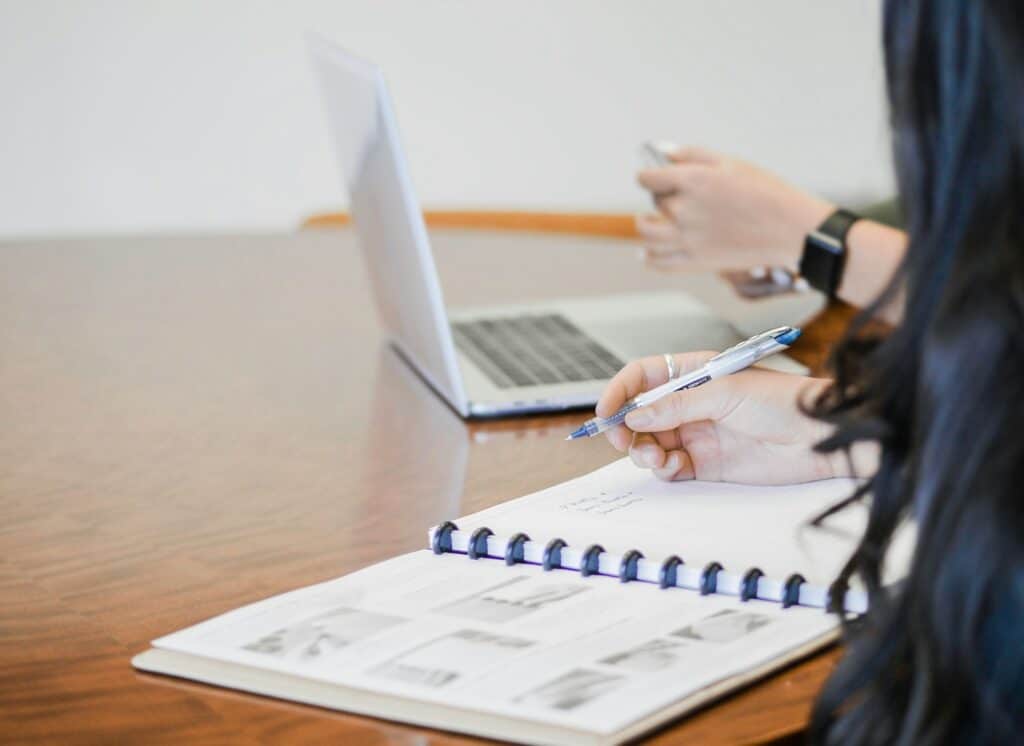 The Benefits of Hiring a CFO Outsourced for Your Business Growth 6 person holding pen writing on paper