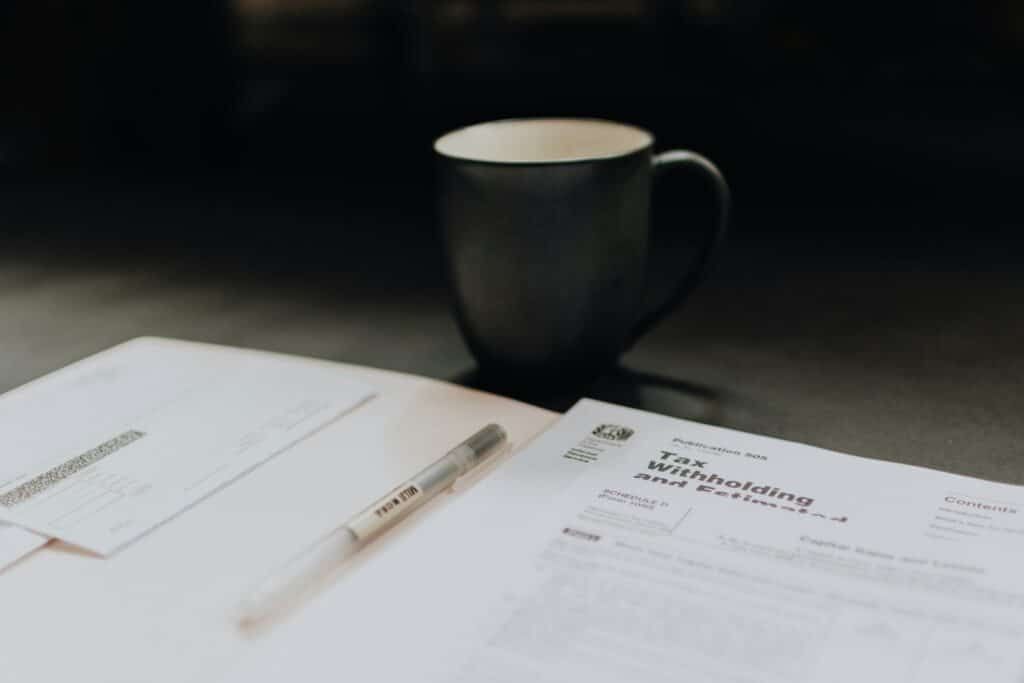Master Your Finances with the Best Tax Planner for Every Need 6 coffee mug near open folder with tax withholding paper