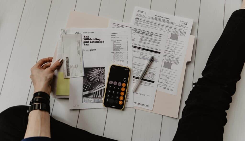 Master Your Finances with the Best Tax Planner for Every Need 8 person holding paper near pen and calculator